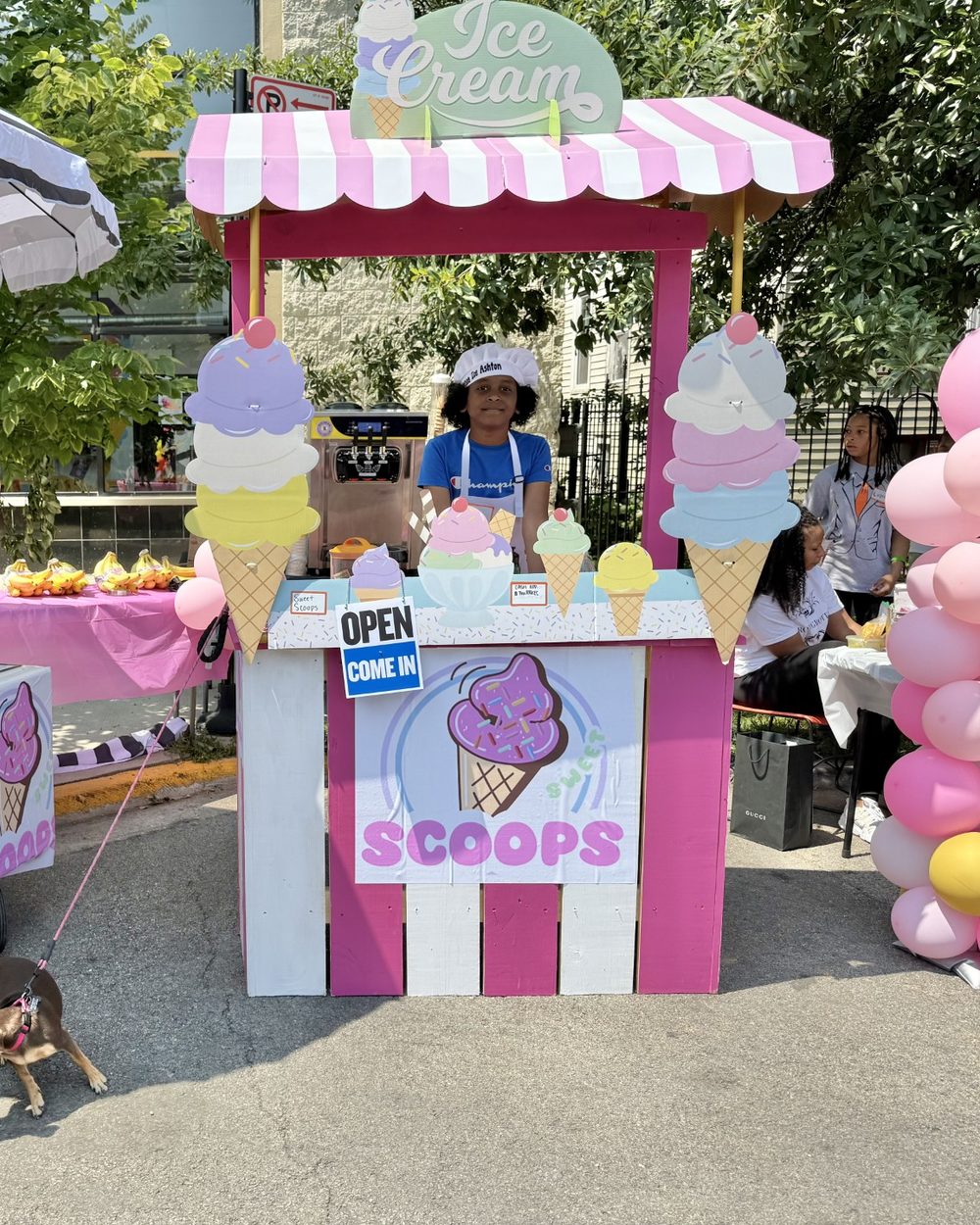 Mini Boss Ashton behind the Sweet Scoops ice cream stand he built and runs